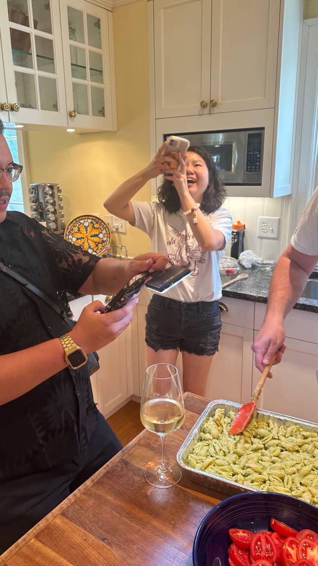 Friends plating fresh pesto pasta at a VARY kitchen event